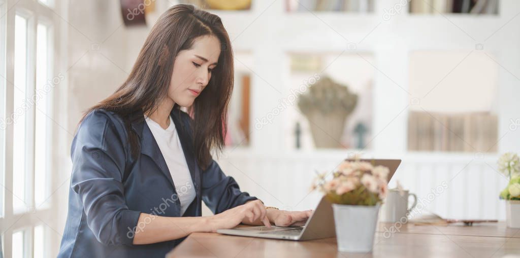 Professional female freelancer working on her project while typi