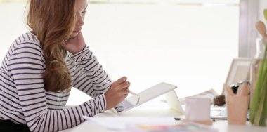 Tutkulu tasarımcı modern tablet ile projesi üzerinde çalışıyor