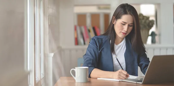 Profesional freelancer femenina trabajando en su proyecto mientras escribe —  Fotos de Stock