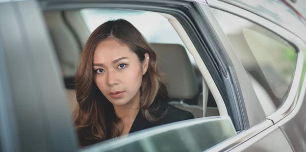 Hermosa mujer de negocios asiática sentada en el asiento trasero del mo — Foto de Stock