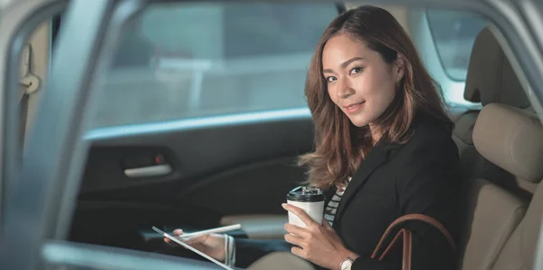 Atractiva mujer de negocios trabajando en el coche con una taza de café — Foto de Stock