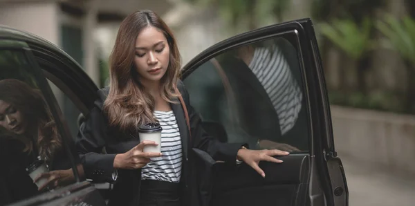 Hermosa mujer de negocios saliendo del moderno coche de lujo whi — Foto de Stock