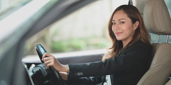 Profesional mujer de negocios mirando a la cámara mientras conduce t — Foto de Stock