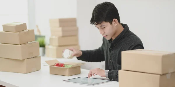 Conceptos de la pequeña empresa: Joven propietario masculino embalaje y venta o — Foto de Stock