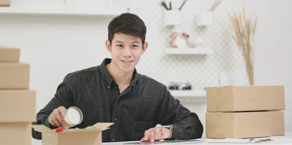 Joven dueño de una pequeña empresa masculina preparando y empaquetando la picana — Foto de Stock