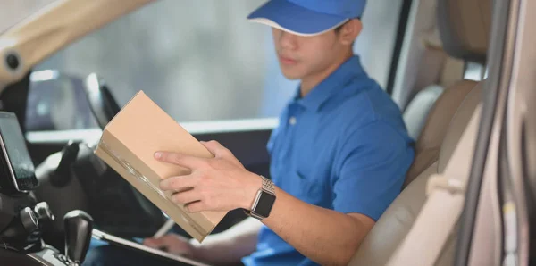 Joven hombre de puesta en marcha comprobar las órdenes para los clientes mientras está sentado en — Foto de Stock