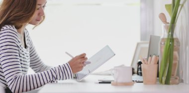 Profesyonel genç tasarımcı tablet üzerinde projesini düzenleme