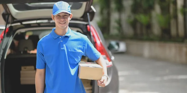 El repartidor prepara la caja de paquetes al cliente y sonríe a la cámara — Foto de Stock