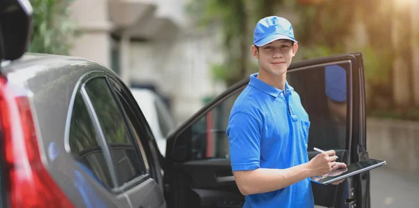 Entrega hombre comprobación de pedidos para el cliente y sonriendo a la cámara — Foto de Stock