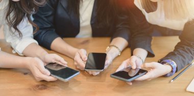 Akıllı telefonda bilgi paylaşan kadın serbest çalışanların yakın çekim görünümü