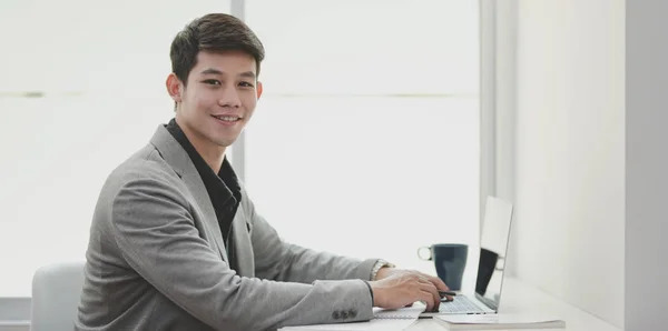 Πορτρέτο του νεαρού επιχειρηματία χαμογελά στην κάμερα ενώ εργάζεται για το έργο του — Φωτογραφία Αρχείου