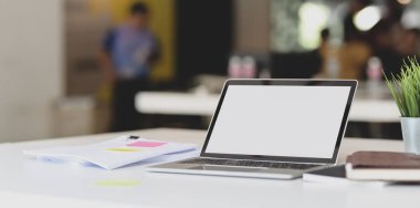 Beyaz masa üzerinde ofis malzemeleri ve belgeleri ile açık dizüstü bilgisayar