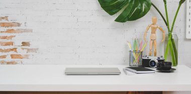 Kamera, dizüstü bilgisayar ve ofis malzemeleri ile konforlu tasarımcı işyeri