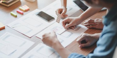 Genç profesyonel Ui grafik tasarımcı ekibi birlikte akıllı telefonlar şablonları hakkında fikir toplama  