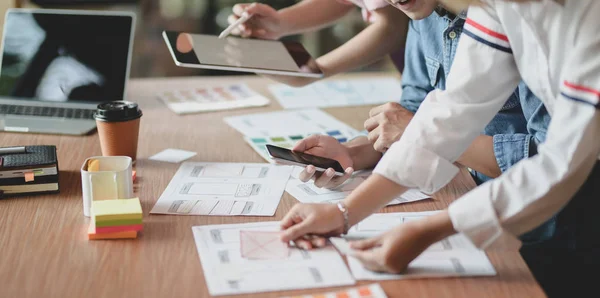 Team of young professional UI graphic designer discussing on their smartphones templates together — Stock Photo, Image