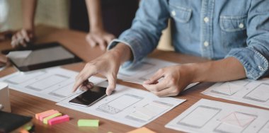 Modern ofis odasında akıllı telefon uygulaması fikrini birlikte planlayan Ux web geliştiricisinin yakın çekim 