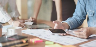 Modern ofis odasında akıllı telefon uygulaması fikrini birlikte planlayan Ux web geliştiricisinin yakın çekim 