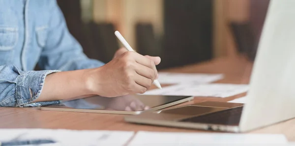 Joven desarrollador web de interfaz de usuario masculino que trabaja en sus plantillas de teléfonos inteligentes con tableta en la oficina moderna — Foto de Stock