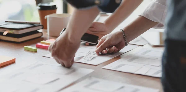 Närbild av unga professionella UI grafisk formgivare team diskuterar på sina smartphones mallar tillsammans — Stockfoto