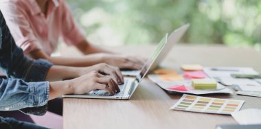 Başarılı Ui web tasarımcısı ekibi dizüstü bilgisayarda yazarken yaklaşan akıllı telefon şablonları üzerinde çalışıyor 