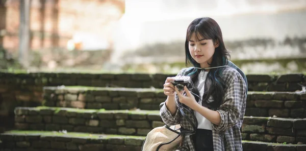 Adorable chica asiática revisando la cámara mientras visita los antiguos lugares históricos — Foto de Stock