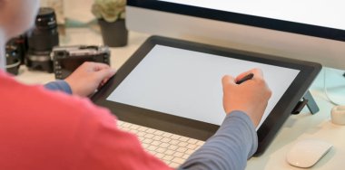 Genç erkek fotoğrafçının işyerindeki dijital tablette görüntülerini rötuşlanın yakın çekim görüntüsü 