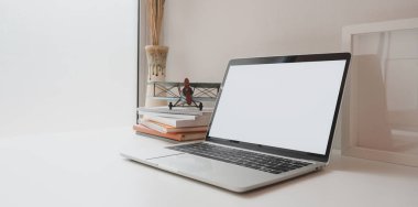 Kopya alanı ve süslemeleri ile minimal işyerinde kahve fincanı ve ofis malzemeleri ile açık boş ekran dizüstü bilgisayar