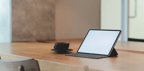 Tableta de pantalla en blanco y una taza de café en un lugar de trabajo cómodo con un ambiente relajante — Foto de Stock