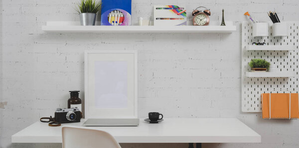 Trendy designer workplace with mock up frame and office supplies on white wooden table with office decorations 
