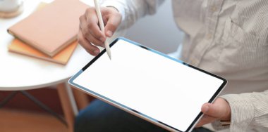 İşadamı bu fikri çalışma alanındaki boş ekran tabletine yazıyor. 