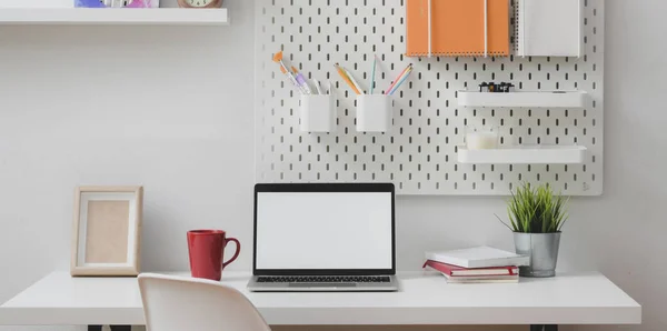Oficina mínima en casa con computadora portátil de pantalla en blanco abierta con artículos de papelería y de oficina —  Fotos de Stock