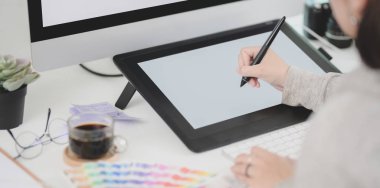 Projesini dijital tabletle düzenleyen genç profesyonel bayan tasarımcının yakın plan görüntüsü 