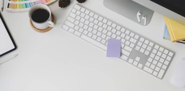 Beyaz masa arkaplanı ve kahve fincanı üzerinde klavye bilgisayarı ve ofis malzemeleri olan modern iş yeri manzarası 