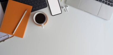 Beyaz ahşap masadaki boş ekran akıllı telefonlu rahat çalışma alanının üst görüntüsü ofis malzemeleri ve kopyalama alanı 