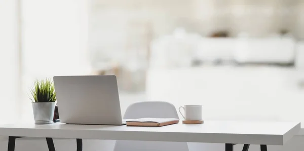 Laptop bilgisayarı, kahve fincanı ve rahatlatıcı atmosferi olan ofis malzemeleri olan rahat bir iş yeri.  