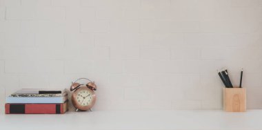 Beyaz ahşap masa ve beyaz tuğla duvar arkaplan üzerinde kopya alanı ve ofis gereçleri olan minimal çalışma alanı