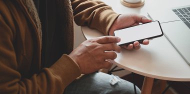 Projesi üzerinde çalışırken elinde boş ekran akıllı telefonu olan adamın yakın plan görüntüsü
