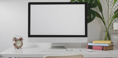 Masaüstü bilgisayarını ofis malzemeleri ve beyaz duvar arkaplanlı dekorasyonlarla minimal ofis tarzında düzenle 