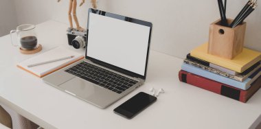 Akıllı telefon ve ofis malzemeleriyle dolu boş dizüstü bilgisayarı olan modern ofis odasının yakın görüntüsü.  