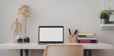 Beyaz ahşap masa üzerinde kitaplarla ve ofis malzemeleriyle boş dizüstü bilgisayarı olan çağdaş iş yeri 