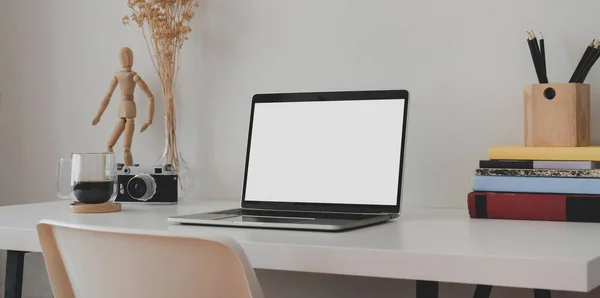 Boş dizüstü bilgisayarı olan, beyaz ahşap masa üzerinde kitap ve ofis malzemeleri olan en küçük ofis odası. — Stok fotoğraf