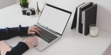 Kadın profesyonel fotoğrafçının boş ekran dizüstü bilgisayarla projesini çekerken görüntüsü kesilmiş. 