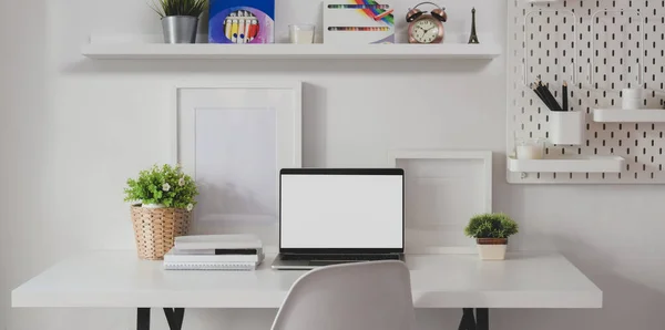 Habitación mínima de oficina en casa con computadora portátil de pantalla abierta en blanco con decoraciones y suministros de oficina —  Fotos de Stock