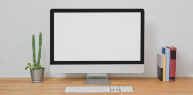 Modern ofis odasındaki masaüstü bilgisayarını ahşap masadaki ofis malzemeleriyle donat. 