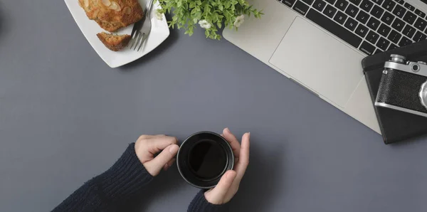 Top view of young female holding coffee cup in winter workspace — Stock Photo, Image