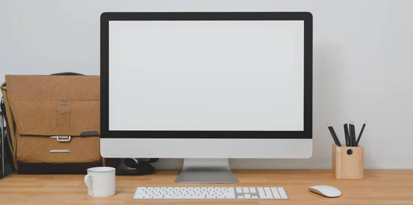 Mock up desktop computer in modern home-office room with office supplies and mailbag on wooden table