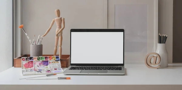 Cómodo espacio de trabajo del artista con ordenador portátil, herramienta de pintura, herramientas de pintura y suministros de oficina —  Fotos de Stock