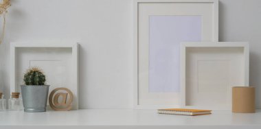 Beyaz duvar arkaplanı ve beyaz tablodaki çerçeve ve dekorasyonları taklit eden en az çalışma alanı 