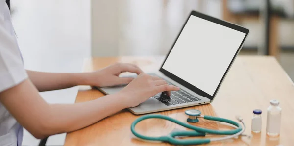 年轻女医生在办公室使用模拟手提电脑检查病人病历的特写 — 图库照片