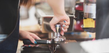 Profesyonel kadın baristanın kahve dükkanında taze kavrulmuş kahve çekirdeklerini öğüttüğü görüntüler. 